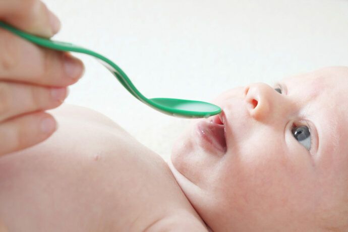 Baby wird Vitamin D Tabletten verabreicht