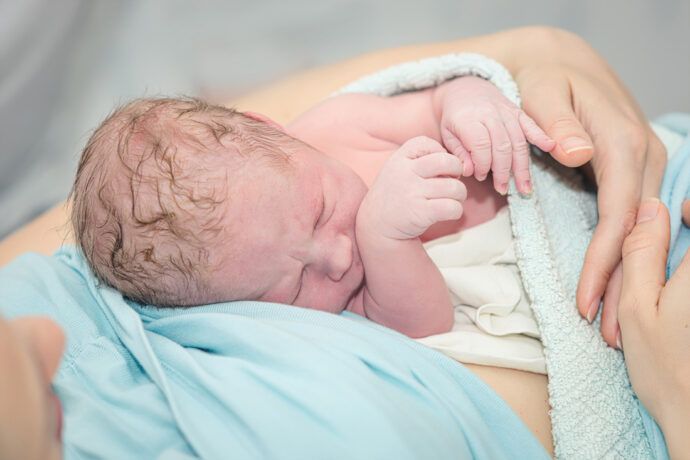 Neugeborenes Baby auf Bauch der Mama