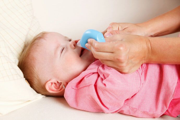Babys Nase wird gesäubert mit Nasensauger