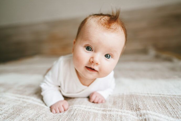 baby 1 monat in bauchlage hält köpfchen hoch