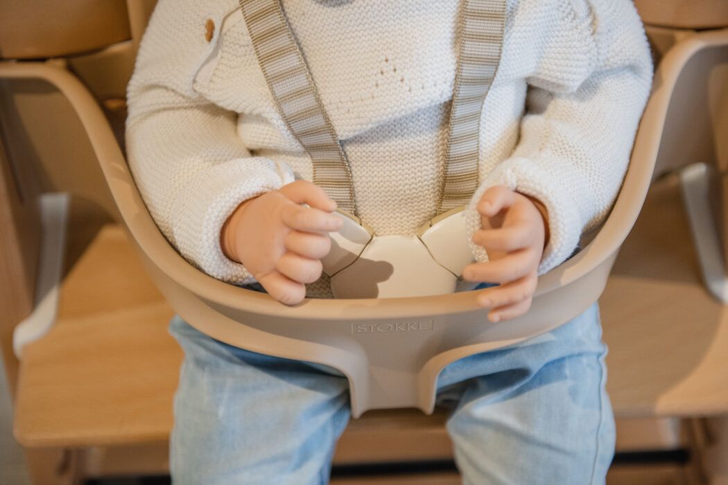 nahaufnahme baby sitzt angeschnallt mit gurt im baby set von stokke