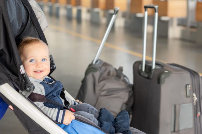 reisen mit baby, baby sitzt im buggy, reisen mit kleinkind, baby koffer flughafen