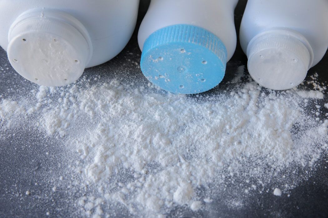babypuder ohne talkum umgekippte puder flaschen auf schwarzem untergrund