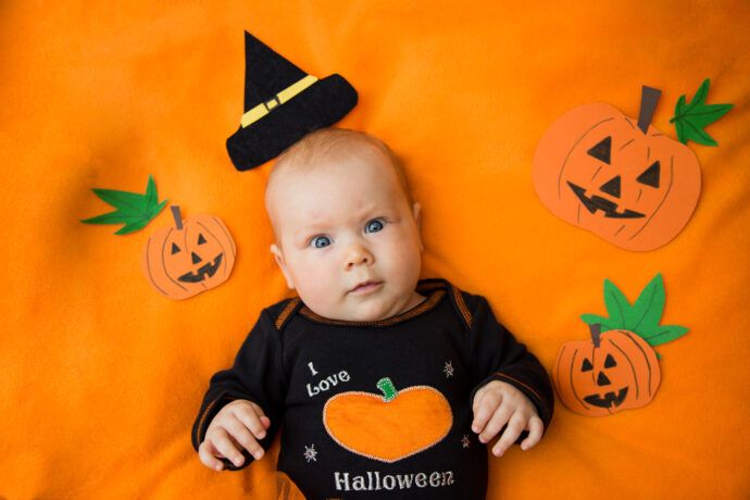 halloween kostuem baby schwarzer body auf orangem hintergrund