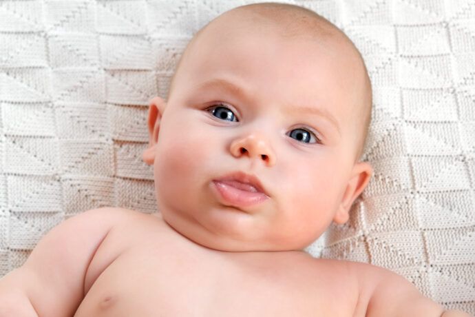 baby schaut unglücklich weil halsfalte wund und rot