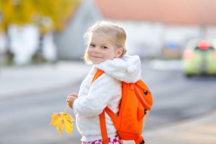 kleines mädchen mit rucksack ist auf dem weg zu tagesmutter oder kita