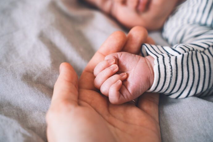 baby kalte hände nachts, fieber, schlafen, draußen; Baby und Mutter halten Händchen, Baby hat nachts kalte Hände, Baby hat immer kalte Hände