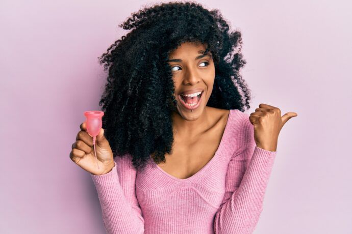lachende frau mit menstruationstasse