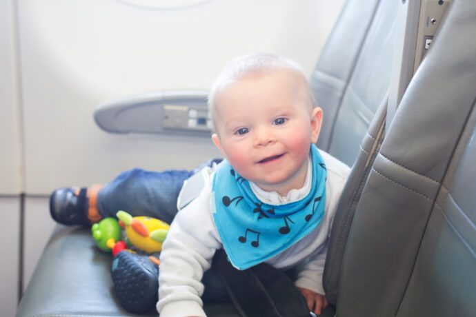 fliegen mit baby kleiner junge spielt fröhlich im flugzeug
