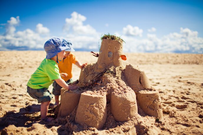 kleinkinder bauen sandburg, kleinkinder im sand, kleinkinder am strand