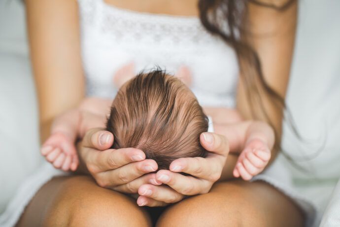 mama hält babys kopf, saugglockengeburt spätfolgen