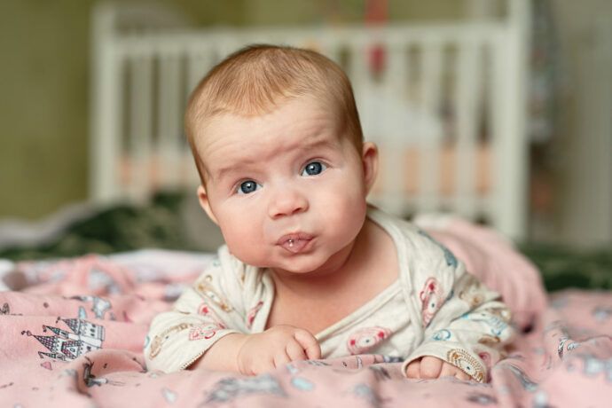 12 wochen schub baby, 3 monate altes baby liegt auf dem bauch und hält seinen kopf selbstständig
