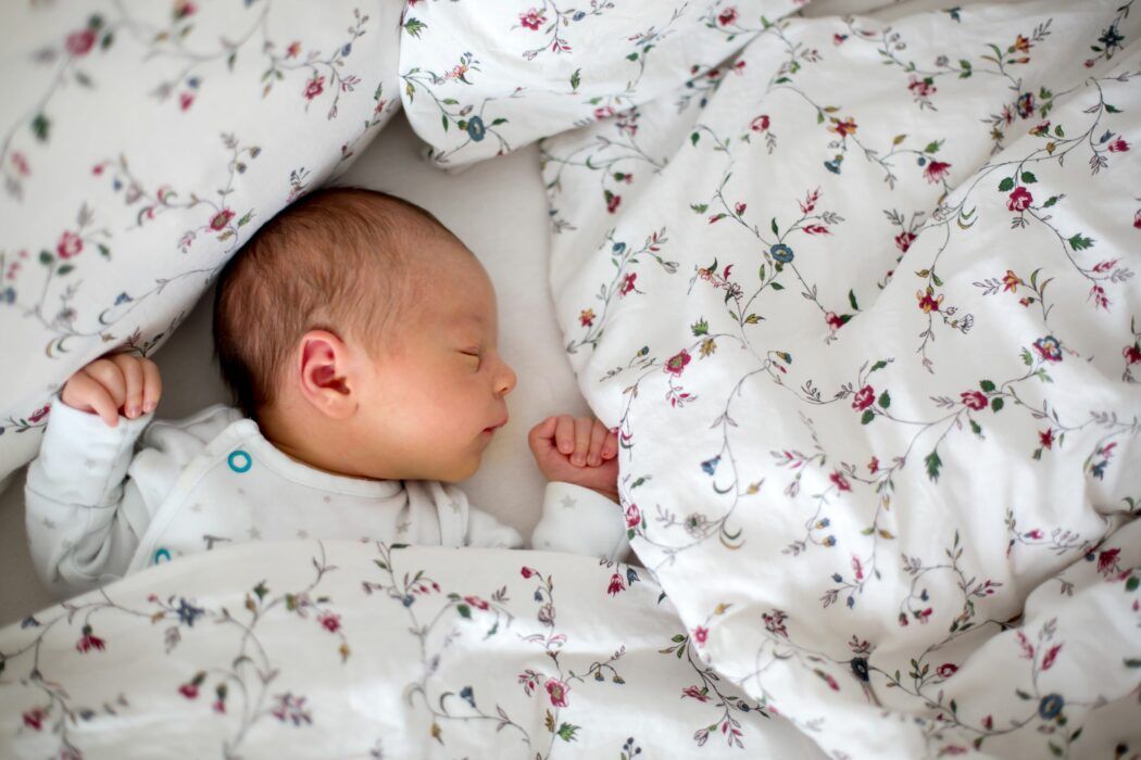 plötzlicher kindstod sids als gefahr für schlafendes baby mit decke um den kopf