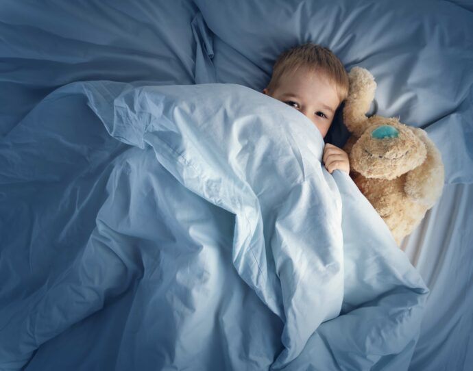 Kleinkind schläft nicht durch, kleinkind durchschlafen lernen, ab wann schläft kleinkind durch, kleiner junge im bett mit kuscheltier