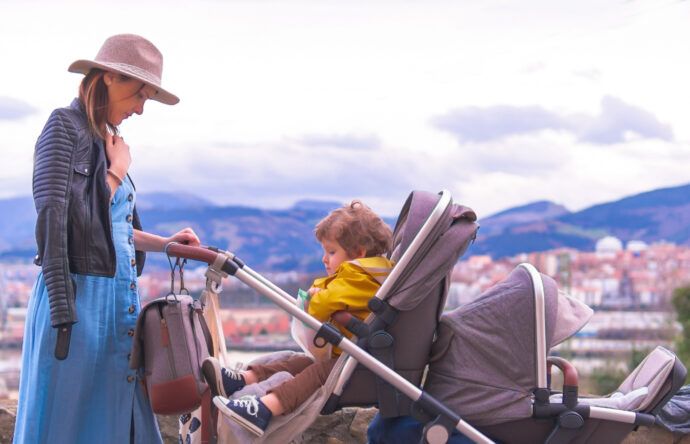 mutter mit baby und kleinkind im geschwisterwagen zwillingswagen