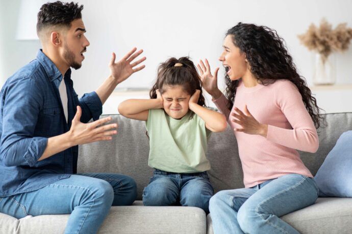 elternstreit in der familie kind sitzt zwischen mutter und vater die sich anschreien