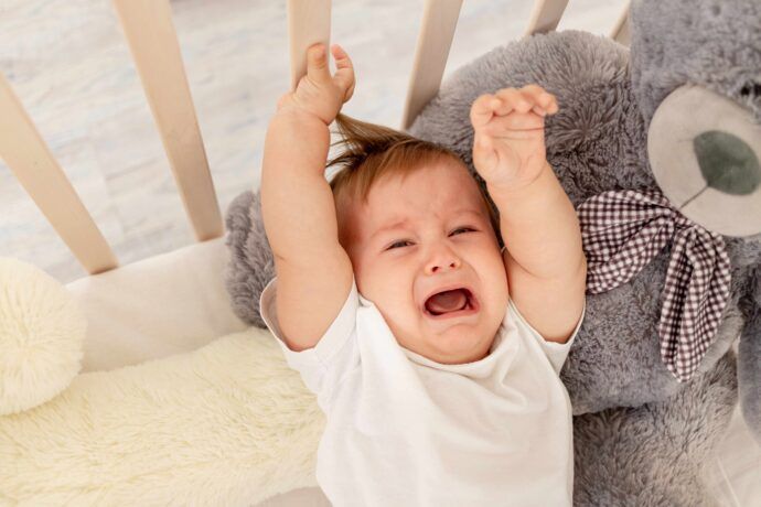 baby im 26 wochen schub liegt im babybett und weint will getragen werden