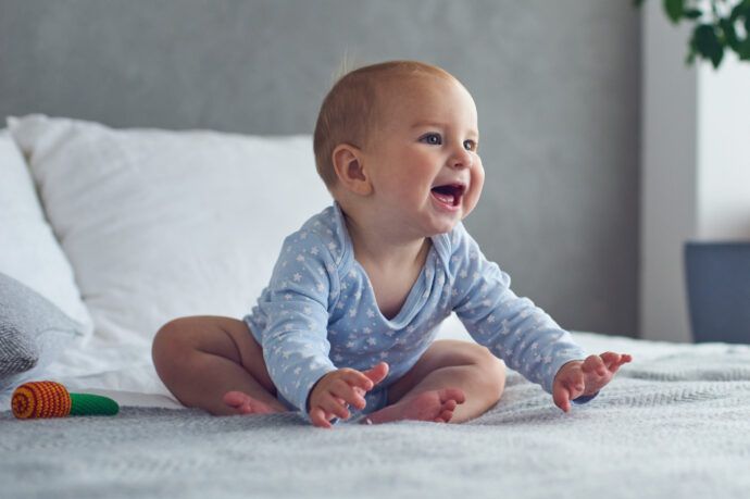 Baby 8 Monate Schlaf, baby 8 Monate sitzt auf Bett, Schlafregression, Essen, Schub, krabbelt nicht, tagesablauf, beschäftigen, spielerisch fördern