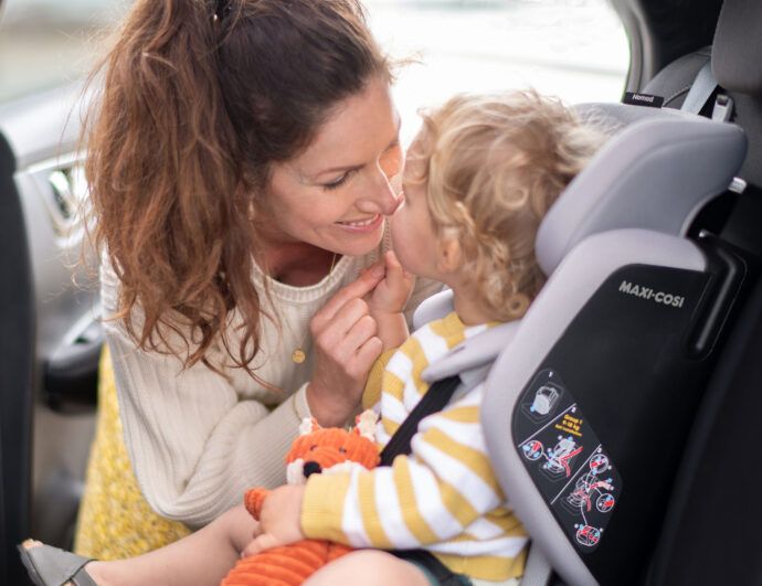 kindersitz ab 1 jahr, maxi cosi nomad, frau setzt kleinkind in den kindersitz