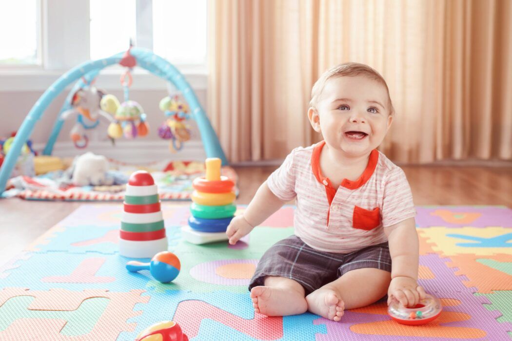 top babyspielzeug von babyartikel.de baby spielt mit rassel spielbogen greifling auf spielmatte