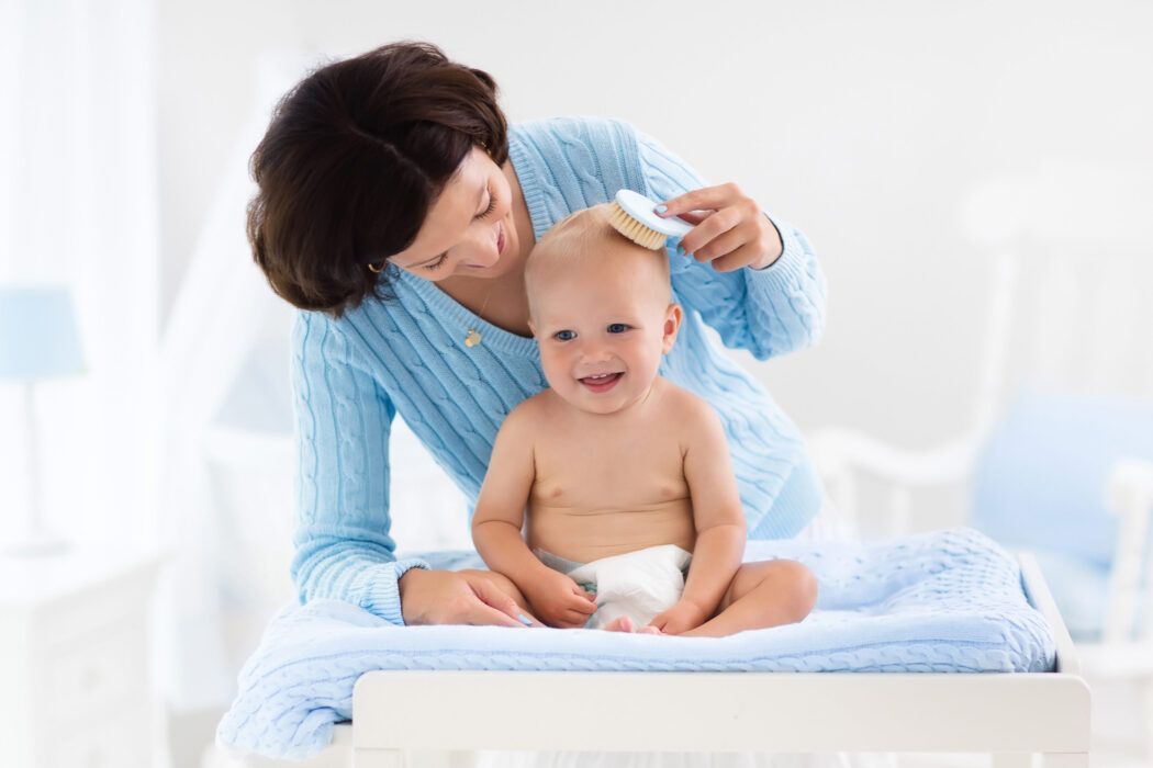 babypflege, mutter bürstet babys haare