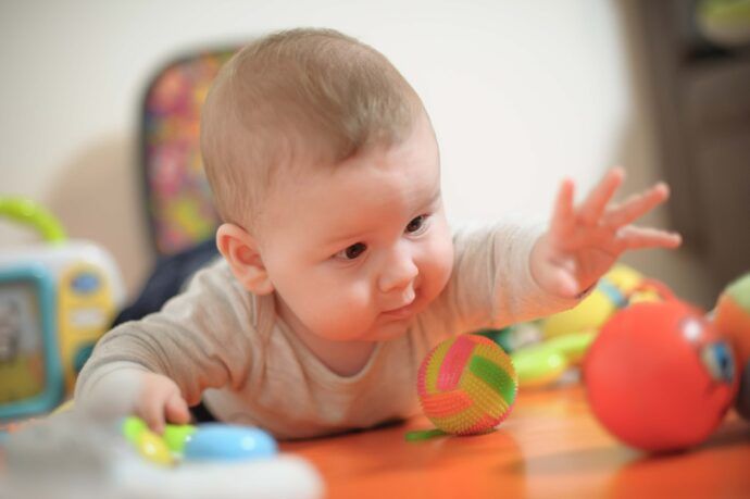 bauchlage baby fördern mit spielzeug ball