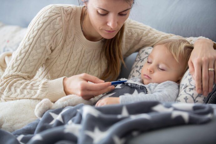 fieber senken mit wadenwickel bei baby und kleinkind mutter mit fieberthermometer neben krankem kind im bett