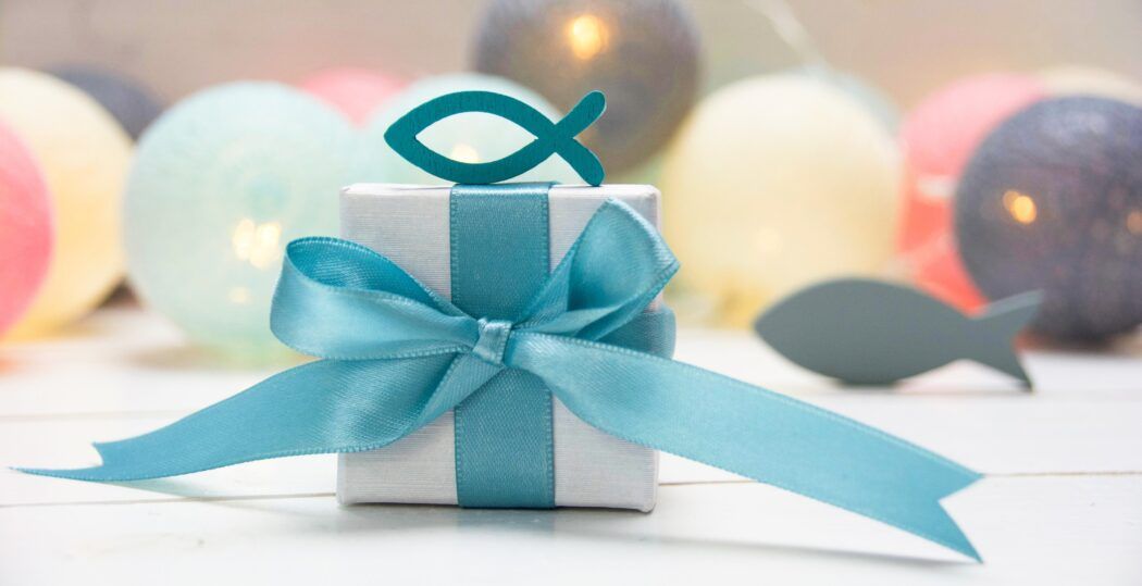 geschenke zur taufe symbolbild mit ballons und chrislichem symbol fisch