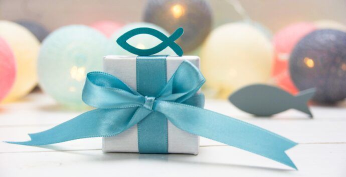 geschenke zur taufe symbolbild mit ballons und chrislichem symbol fisch