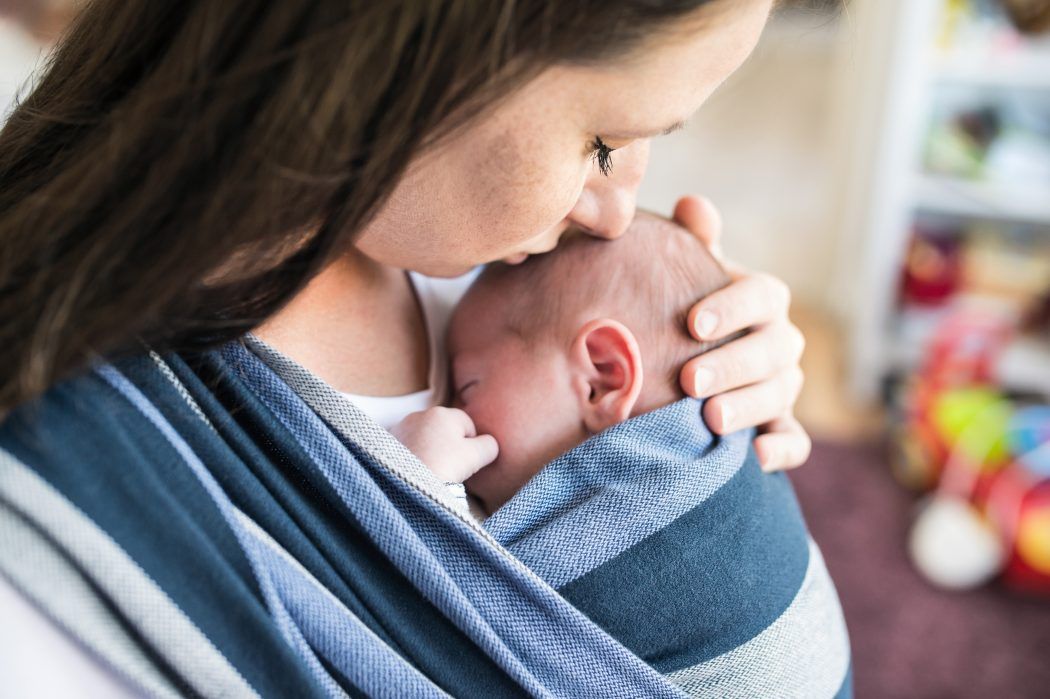 baby im tragetuch, mutter küsst baby auf kopf, baby quengelt im kinderwagen, baby beruhigen