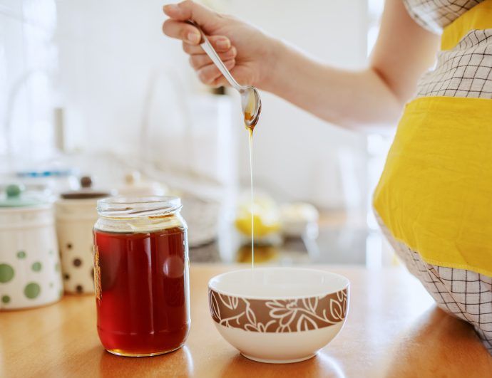 honig in der schwangerschaft, frau mit babybauch bereitet heiße milch mit honig zu