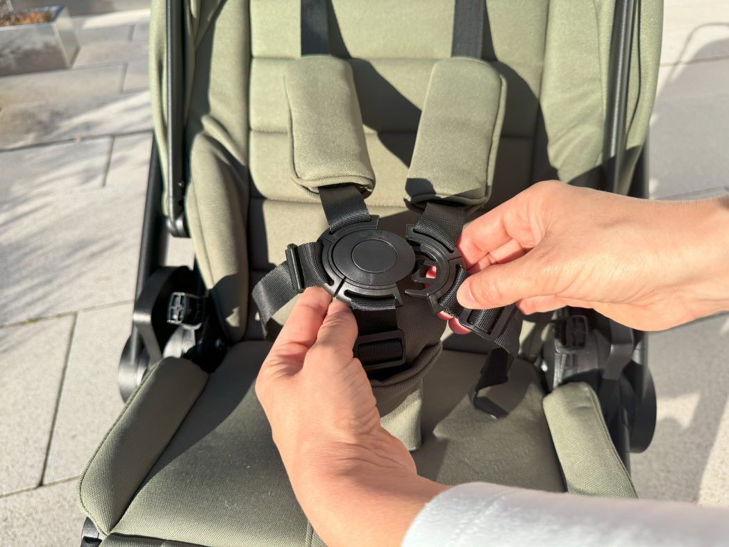 moon resea+ test person schliesst clip verschluss am 5-punkt-gurt