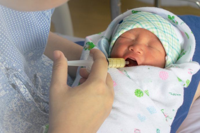 baby wird mit spritze mit kolostrum und muttermilch gefüttert, kolostrum ausstreichen vor geburt, kolostrum einfrieren, kolostrum ausstreichen ab wann, wehen fördern