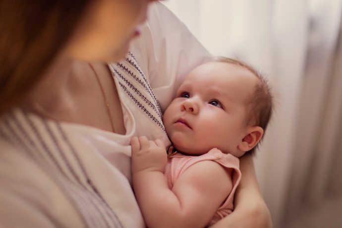 Baby Halsschmerzen, Mutter hält Baby im Arm