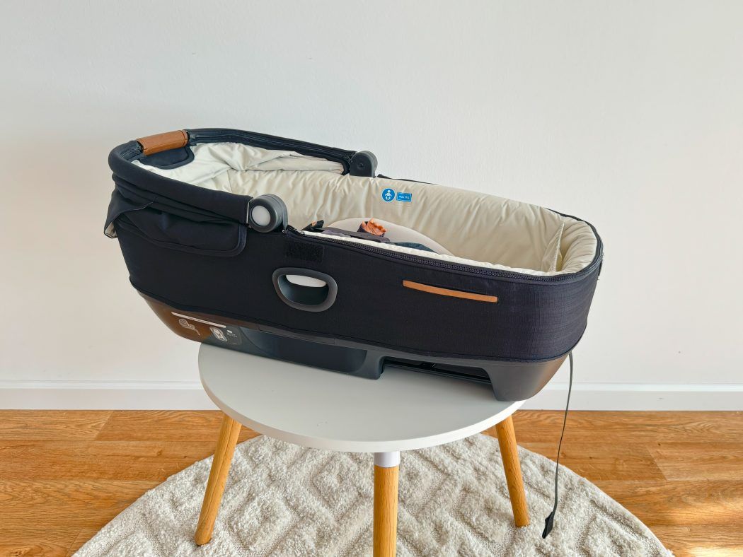 seitenansicht baby liegt in joie calmi auto babywanne verdeck offen