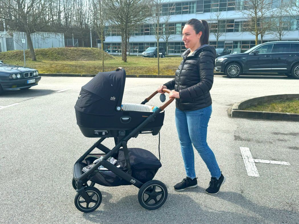 person schiebt vinca kinderwagen mit auto babywanne joie calmi r129