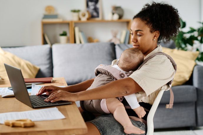Plötzlich alleinerziehend: Mutter mit Baby vor dem Computer