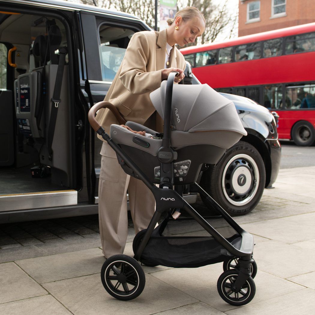 mutter setzt babyschale nuna pipa urbn r129 mit adapter auf kinderwagen gestell city life