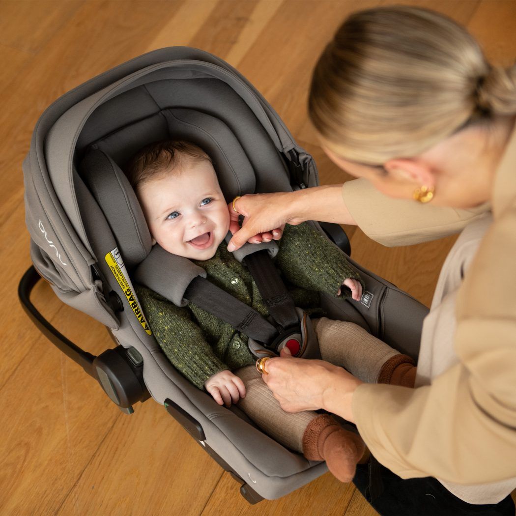 mutter spielt mit lachendem baby in leichter babyschale nuna pipa urbn r129