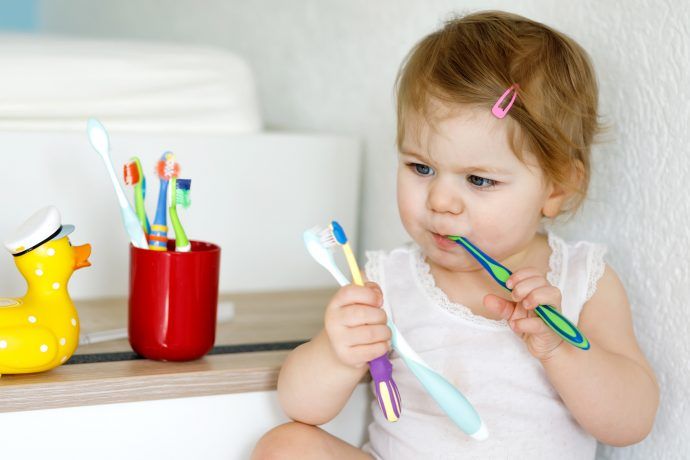 Kinderzahnbürste Test Ökotest 2024, kleines Mädchen mit Zahnbürsten