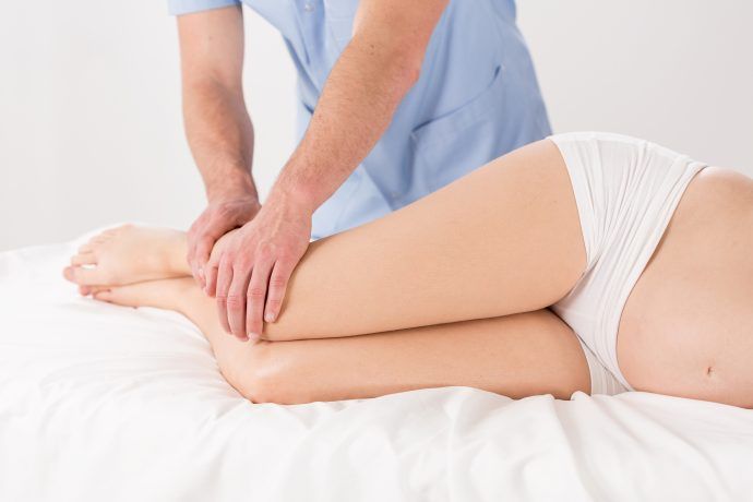 lymphdrainage schwangerschaft gegen wassereinlagerungen ödeme, schwangere wird an den beinen massiert