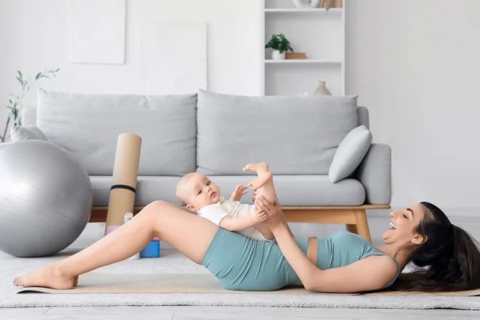 ab wann rückbildung nach kaiserschnitt, frau mit baby macht übungen zur rückbildung nach geburt
