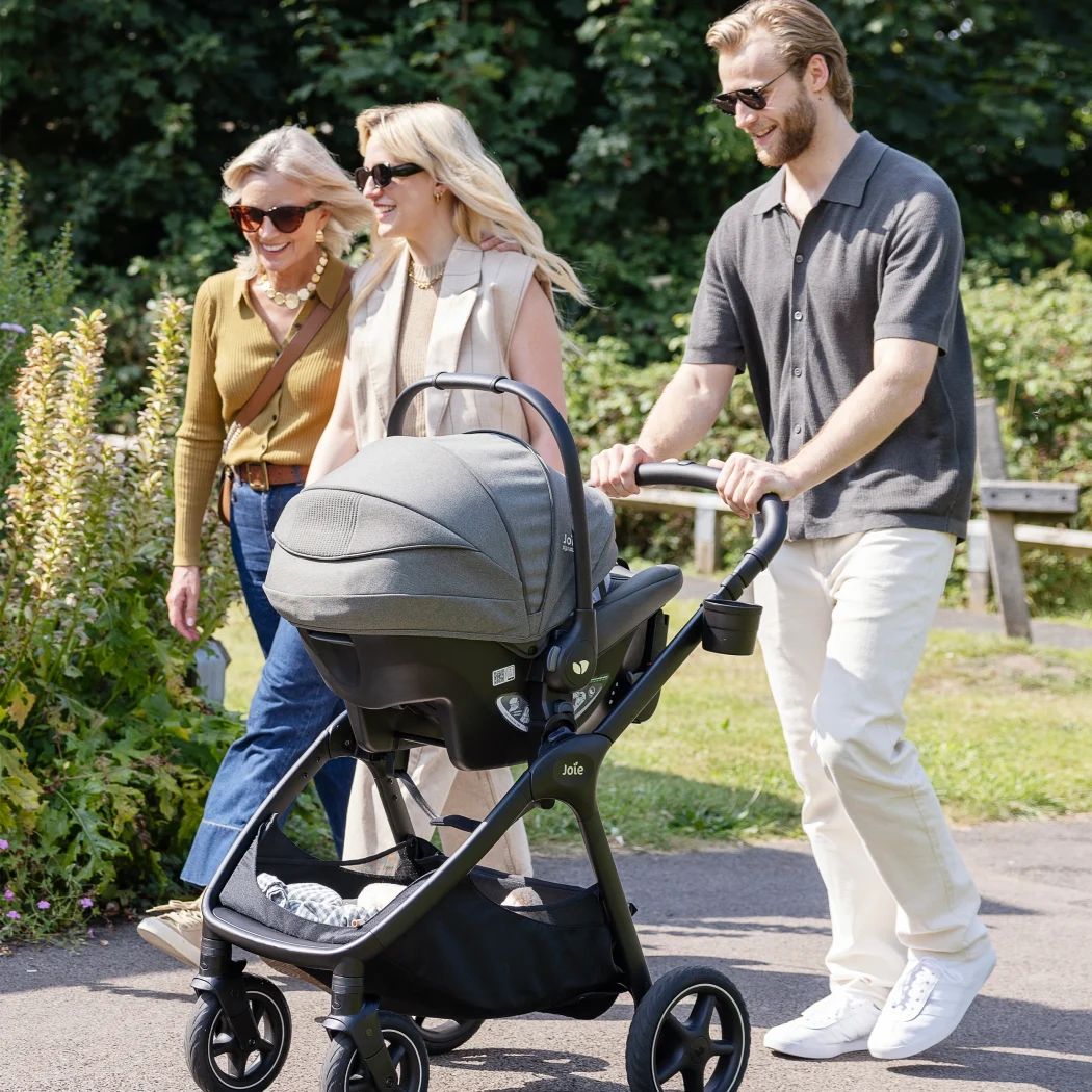 joie sprint babyschale travelsystem auf kinderwagen gestell drei personen spaziergang park